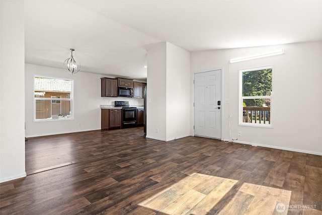 22106 Cedarview Dr E, Bonney Lake, WA 98391 - unfurnished living room featuring a chandelier, dark wood-type flooring, and baseboards