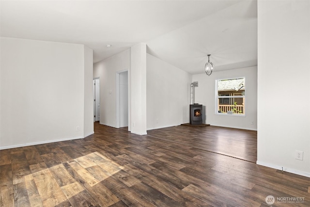 22106 Cedarview Dr E, Bonney Lake, WA 98391 - unfurnished living room featuring a wood stove, dark wood-style floors, lofted ceiling, baseboards, and a chandelier