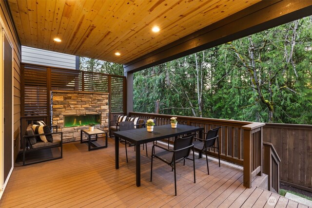 1201 222nd Ct SE, Sammamish, WA 98075 - wooden terrace with an outdoor stone fireplace and outdoor dining area