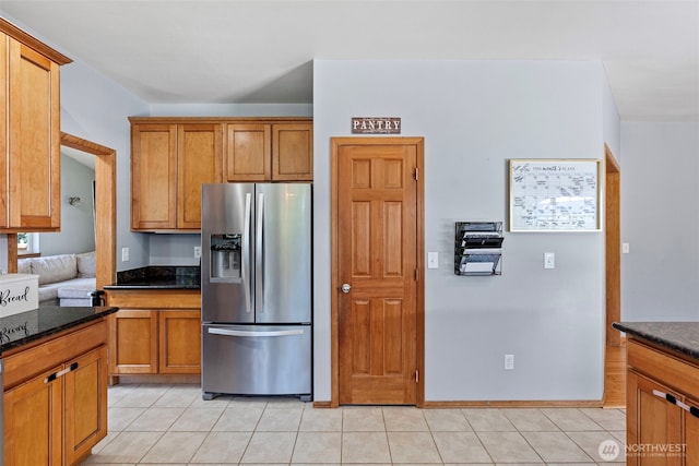 201 E Park Loop, Shelton, WA 98584 - kitchen with stainless steel fridge with ice dispenser, brown cabinetry, dark stone countertops, and light tile patterned flooring