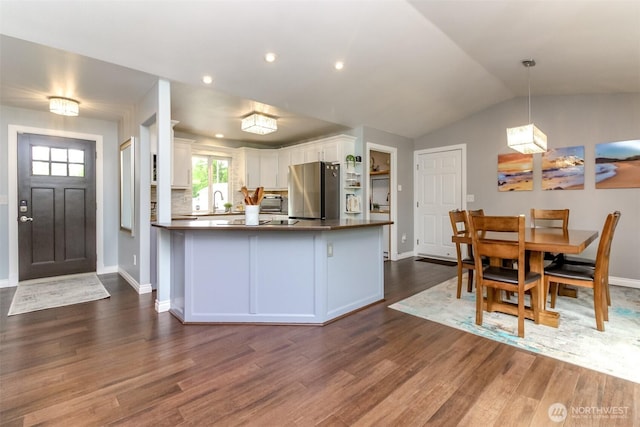14918 Champion Estates Dr SE, Yelm, WA 98597 - kitchen featuring freestanding refrigerator, white cabinetry, dark wood-style flooring, dark countertops, and vaulted ceiling