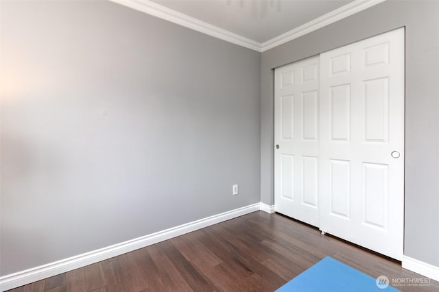 14918 Champion Estates Dr SE, Yelm, WA 98597 - unfurnished bedroom featuring crown molding, dark wood-style flooring, and a closet