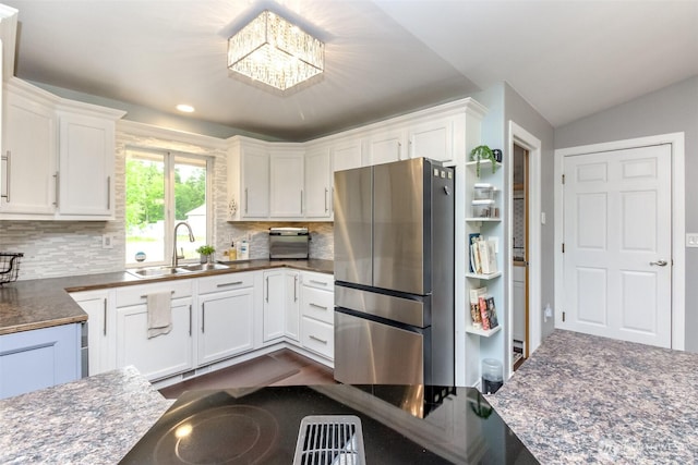 14918 Champion Estates Dr SE, Yelm, WA 98597 - kitchen with freestanding refrigerator, dark countertops, white cabinetry, tasteful backsplash, and lofted ceiling