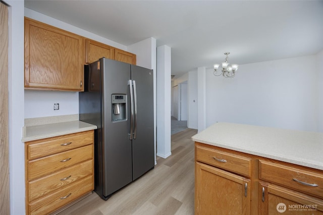 1105 200th Street Ct E, Spanaway, WA 98387 - kitchen featuring stainless steel fridge with ice dispenser, light wood-type flooring, a chandelier, light countertops, and brown cabinets