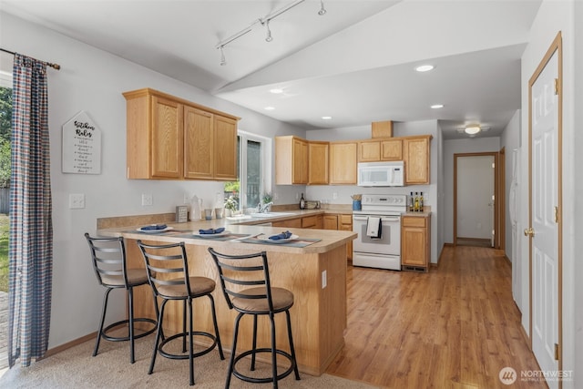 8432 Pepperidge Ln SE, Yelm, WA 98597 - kitchen with white appliances, vaulted ceiling, a peninsula, light countertops, and a breakfast bar area