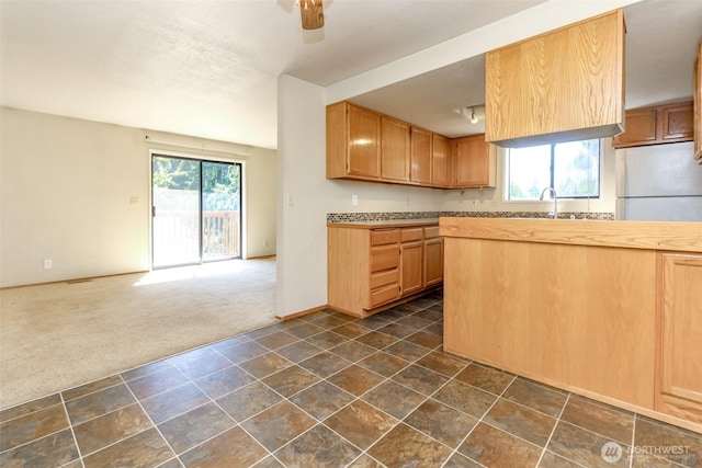 7620 194th Ave E, Bonney Lake, WA 98391 - kitchen featuring dark colored carpet, freestanding refrigerator, open floor plan, and ceiling fan