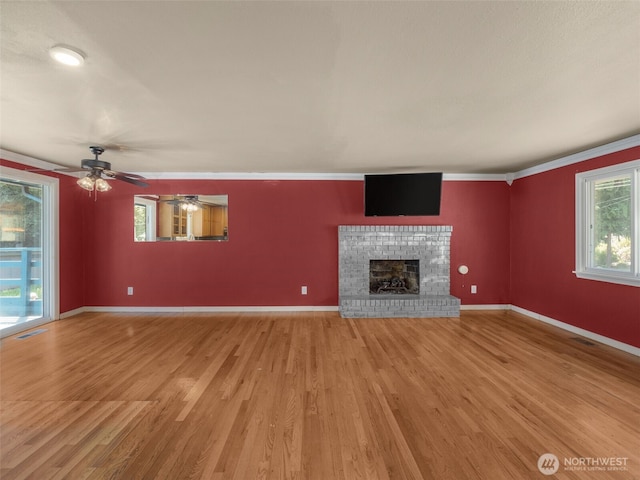 11822 10th Ave S, Seattle, WA 98168 - unfurnished living room with light wood finished floors, a fireplace, ceiling fan, and ornamental molding