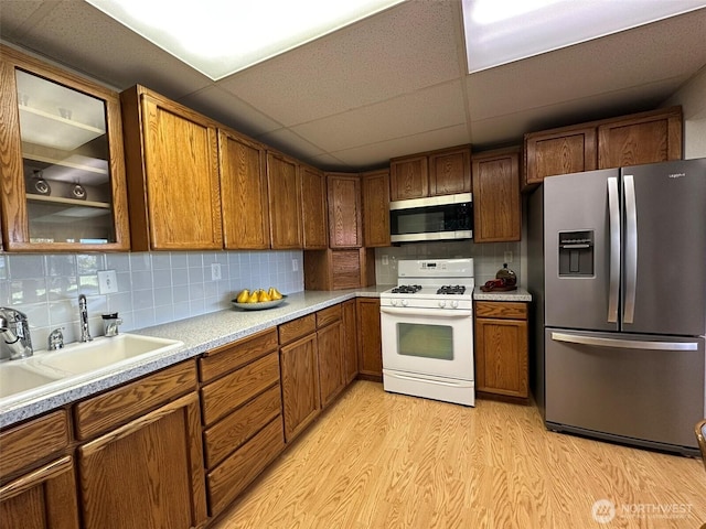 714 SW 296th St, Federal Way, WA 98023 - kitchen featuring stainless steel appliances, light wood finished floors, a sink, brown cabinets, and light countertops