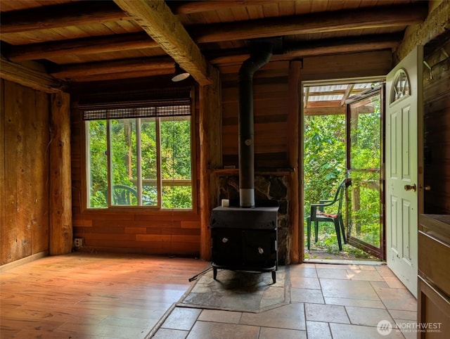 12508 Kellogg Lake Rd, Sultan, WA 98294 - foyer entrance with a wooden ceiling with exposed beams, a wood stove, wood walls, and stone tile floors