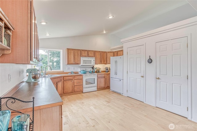 1649 Denise Cir, Wenatchee, WA 98801 - kitchen with white appliances, a sink, lofted ceiling, light wood-style floors, and brown cabinetry