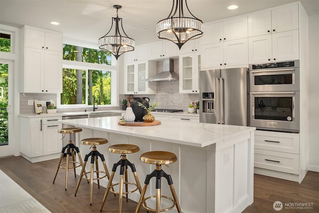 19722 Filbert Dr Unit B-3, Bothell, WA 98012 - kitchen featuring appliances with stainless steel finishes, wall chimney range hood, a center island, a chandelier, and decorative backsplash