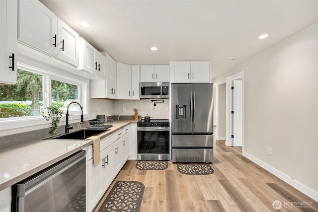 8206 N Way SW, Lakewood, WA 98498 - kitchen with appliances with stainless steel finishes, a sink, white cabinetry, light wood finished floors, and recessed lighting
