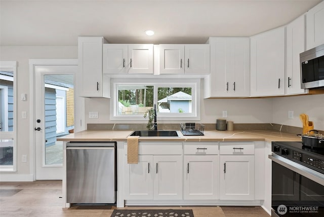 8206 N Way SW, Lakewood, WA 98498 - kitchen with stainless steel appliances, a sink, light countertops, white cabinets, and recessed lighting