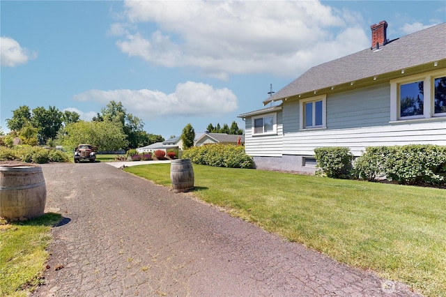 1250 Bryant, Walla Walla, WA 99362 - view of home's exterior with a chimney, a lawn, dirt driveway, and a shingled roof