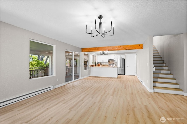 3801 Ruddell Rd SE, Lacey, WA 98503 - unfurnished living room featuring a baseboard radiator, a chandelier, light wood-style floors, stairs, and baseboard heating
