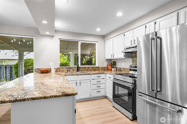 3801 Ruddell Rd SE, Lacey, WA 98503 - kitchen with stainless steel appliances, a peninsula, healthy amount of natural light, white cabinets, and recessed lighting