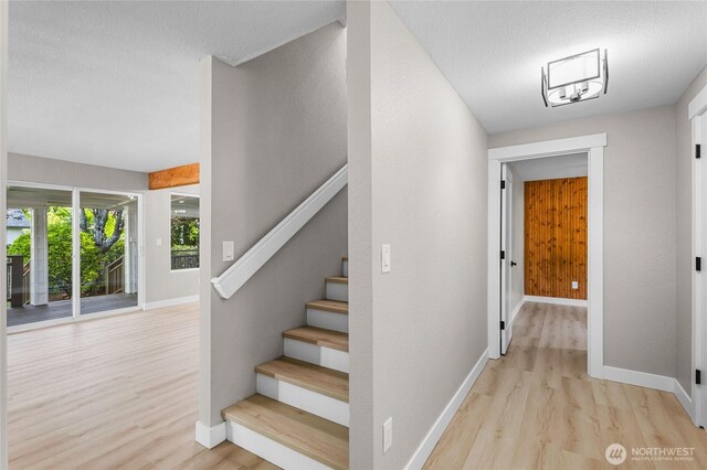 3801 Ruddell Rd SE, Lacey, WA 98503 - stairs with wood finished floors, baseboards, and a textured ceiling