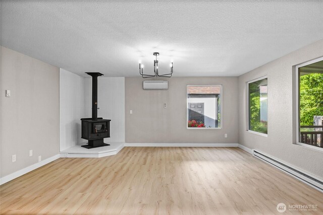 3801 Ruddell Rd SE, Lacey, WA 98503 - unfurnished living room with baseboard heating, wood finished floors, a textured ceiling, baseboards, and a chandelier