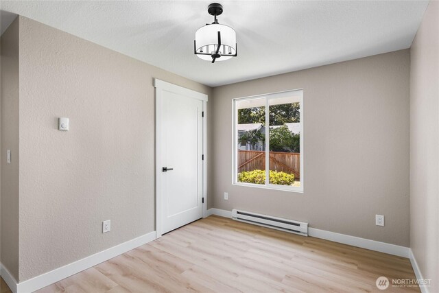 3801 Ruddell Rd SE, Lacey, WA 98503 - spare room featuring a baseboard radiator, wood finished floors, and baseboards