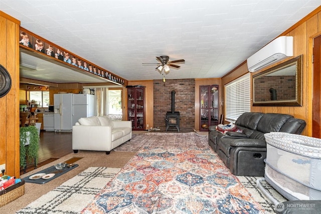 300 Brim Rd, Onalaska, WA 98570 - carpeted living room featuring a wood stove, a wall unit AC, ceiling fan, and wooden walls