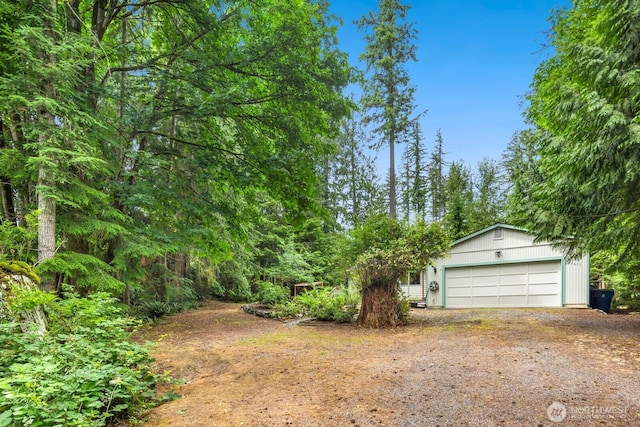 23611 Friar Creek Rd, Monroe, WA 98272 - view of yard featuring dirt driveway, an attached garage, and an outbuilding