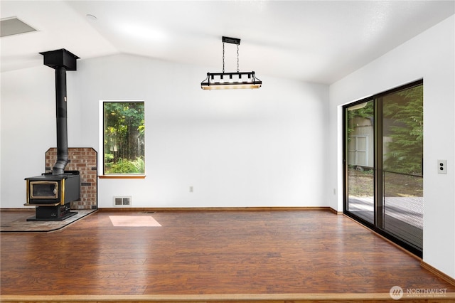 23611 Friar Creek Rd, Monroe, WA 98272 - unfurnished living room featuring vaulted ceiling, a wood stove, and wood finished floors