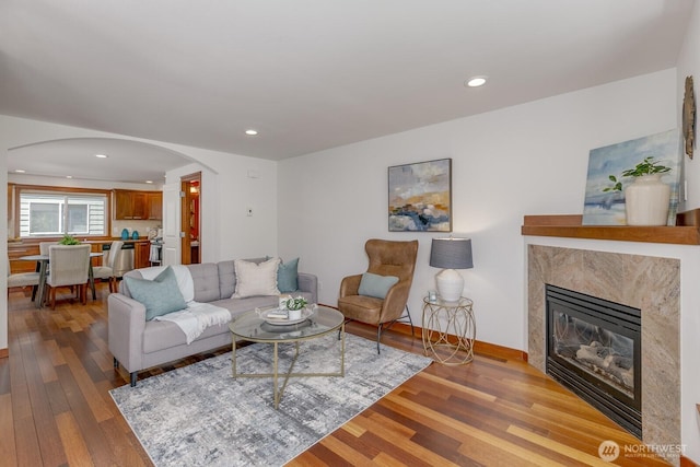 12046 33rd Ave NE Unit A, Seattle, WA 98125 - living room with arched walkways, wood finished floors, a fireplace, recessed lighting, and baseboards