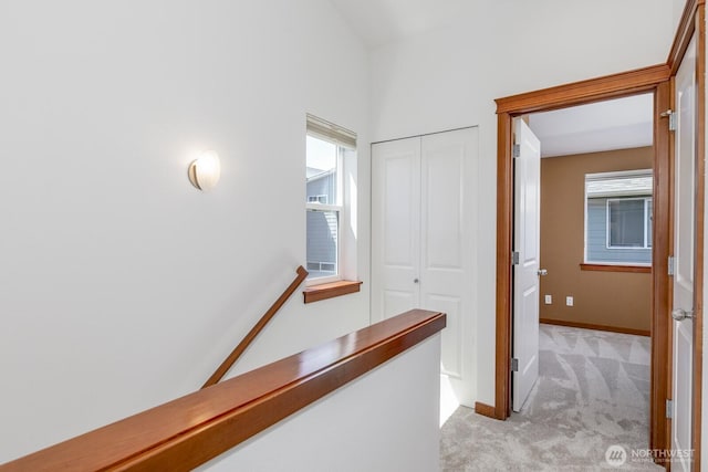 12046 33rd Ave NE Unit A, Seattle, WA 98125 - hallway featuring light carpet, baseboards, and an upstairs landing