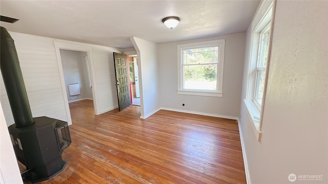 7459 Blaine Rd, Blaine, WA 98230 - unfurnished room featuring light wood-type flooring, a wood stove, and baseboards