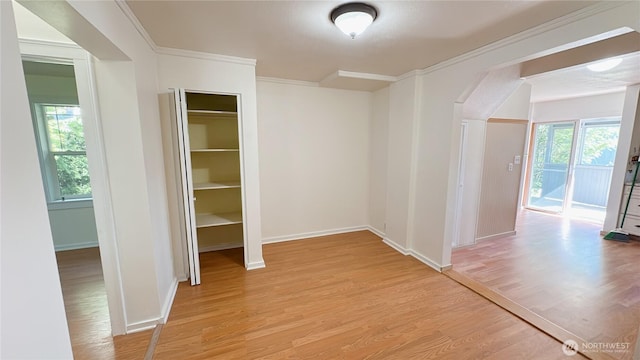 7459 Blaine Rd, Blaine, WA 98230 - hallway featuring light wood-style floors, baseboards, crown molding, and arched walkways