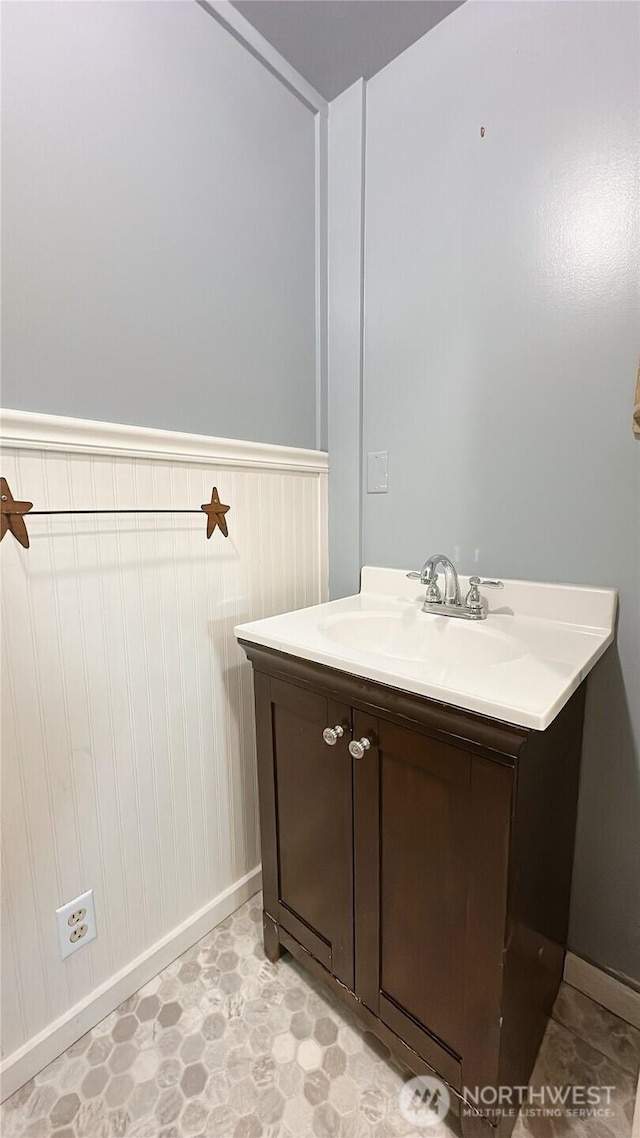 7459 Blaine Rd, Blaine, WA 98230 - bathroom featuring vanity, baseboards, a wainscoted wall, and tile patterned floors