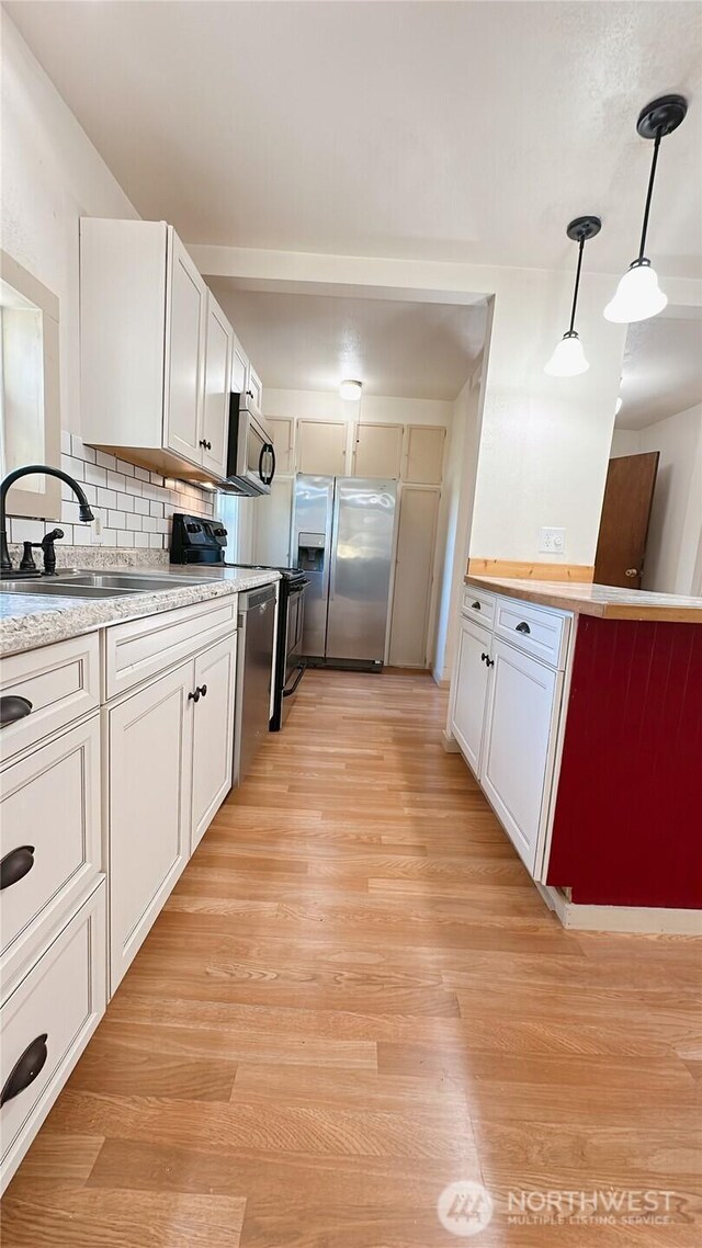 7459 Blaine Rd, Blaine, WA 98230 - kitchen with appliances with stainless steel finishes, a sink, light wood finished floors, and pendant lighting