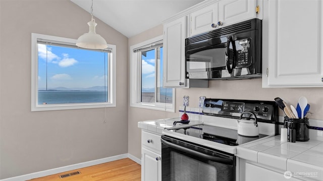 1042 Shorecrest Pl, Camano Island, WA 98282 - kitchen with black appliances, tile counters, lofted ceiling, white cabinets, and light wood-style floors