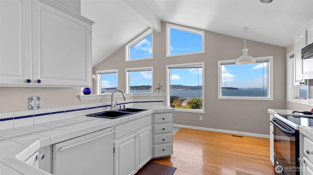 1042 Shorecrest Pl, Camano Island, WA 98282 - kitchen featuring white dishwasher, black / electric stove, tile counters, white cabinetry, and light wood finished floors