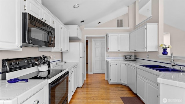 1042 Shorecrest Pl, Camano Island, WA 98282 - kitchen with black appliances, tile counters, vaulted ceiling, and white cabinets