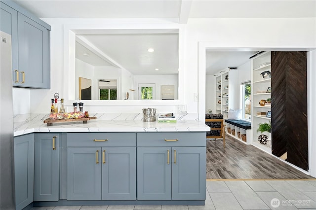 10056 Interlake Ave N, Seattle, WA 98133 - kitchen with light stone counters, light tile patterned floors, recessed lighting, freestanding refrigerator, and gray cabinetry
