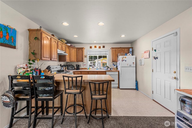 2509 Boston Ave NW, East Wenatchee, WA 98802 - kitchen with white appliances, under cabinet range hood, a peninsula, light countertops, and a sink