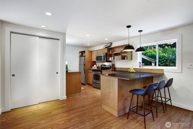 9030 6th Ave NW, Seattle, WA 98117 - kitchen featuring appliances with stainless steel finishes, open shelves, light wood-style floors, a kitchen breakfast bar, and recessed lighting
