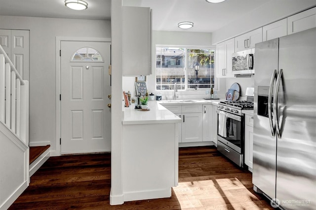 6128 202nd St SW Unit 101, Lynnwood, WA 98036 - kitchen with appliances with stainless steel finishes, light countertops, dark wood-style flooring, and white cabinets