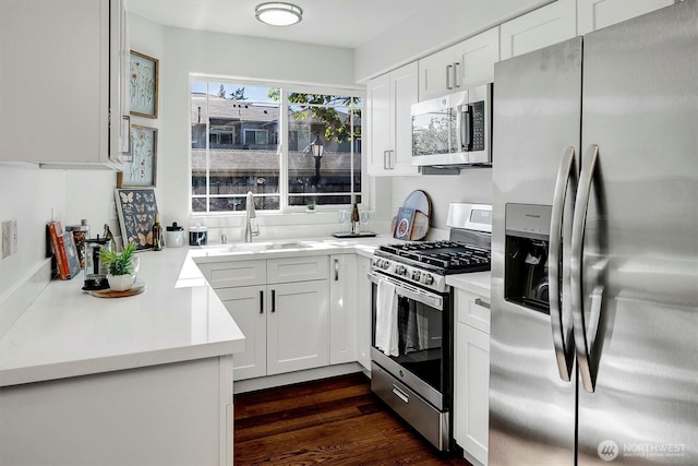 6128 202nd St SW Unit 101, Lynnwood, WA 98036 - kitchen with appliances with stainless steel finishes, white cabinetry, light countertops, and dark wood-style flooring
