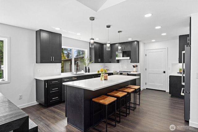 16100 SE 113th Pl, Renton, WA 98059 - kitchen featuring a sink, a kitchen breakfast bar, light countertops, dark wood-type flooring, and recessed lighting