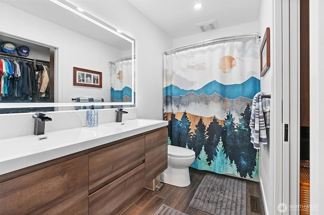 16100 SE 113th Pl, Renton, WA 98059 - full bath with double vanity, a spacious closet, wood finished floors, toilet, and recessed lighting