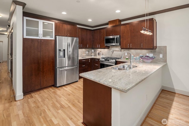 18609 SE Newport Way Unit 408, Issaquah, WA 98027 - kitchen with stainless steel appliances, a sink, a peninsula, light wood-style floors, and baseboards
