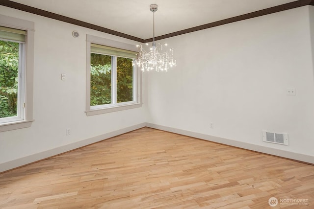 18609 SE Newport Way Unit 408, Issaquah, WA 98027 - spare room with a chandelier, light wood finished floors, baseboards, and ornamental molding