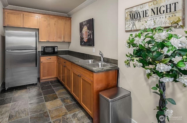 18609 SE Newport Way Unit 408, Issaquah, WA 98027 - kitchen featuring freestanding refrigerator, a sink, black microwave, crown molding, and stone finish flooring