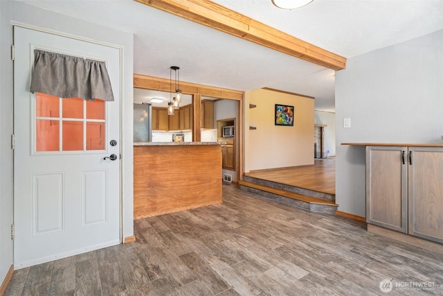 2526 19th St, Bremerton, WA 98312 - kitchen featuring beamed ceiling, wood finished floors, baseboards, stainless steel microwave, and decorative light fixtures