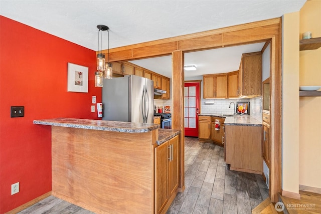 2526 19th St, Bremerton, WA 98312 - kitchen featuring stainless steel appliances, brown cabinets, dark wood-style floors, backsplash, and dark countertops
