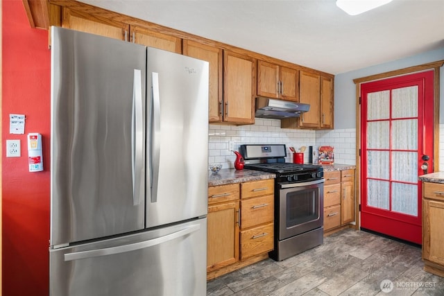 2526 19th St, Bremerton, WA 98312 - kitchen with appliances with stainless steel finishes, under cabinet range hood, backsplash, brown cabinets, and dark wood-style floors