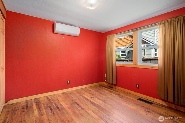 2526 19th St, Bremerton, WA 98312 - unfurnished room with a wall unit AC, wood finished floors, and baseboards