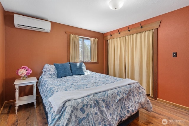 2526 19th St, Bremerton, WA 98312 - bedroom with an AC wall unit, wood finished floors, and baseboards